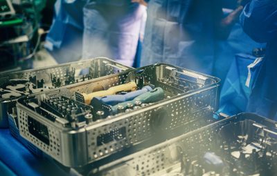 surgical tools organized in metal trays on a blue background