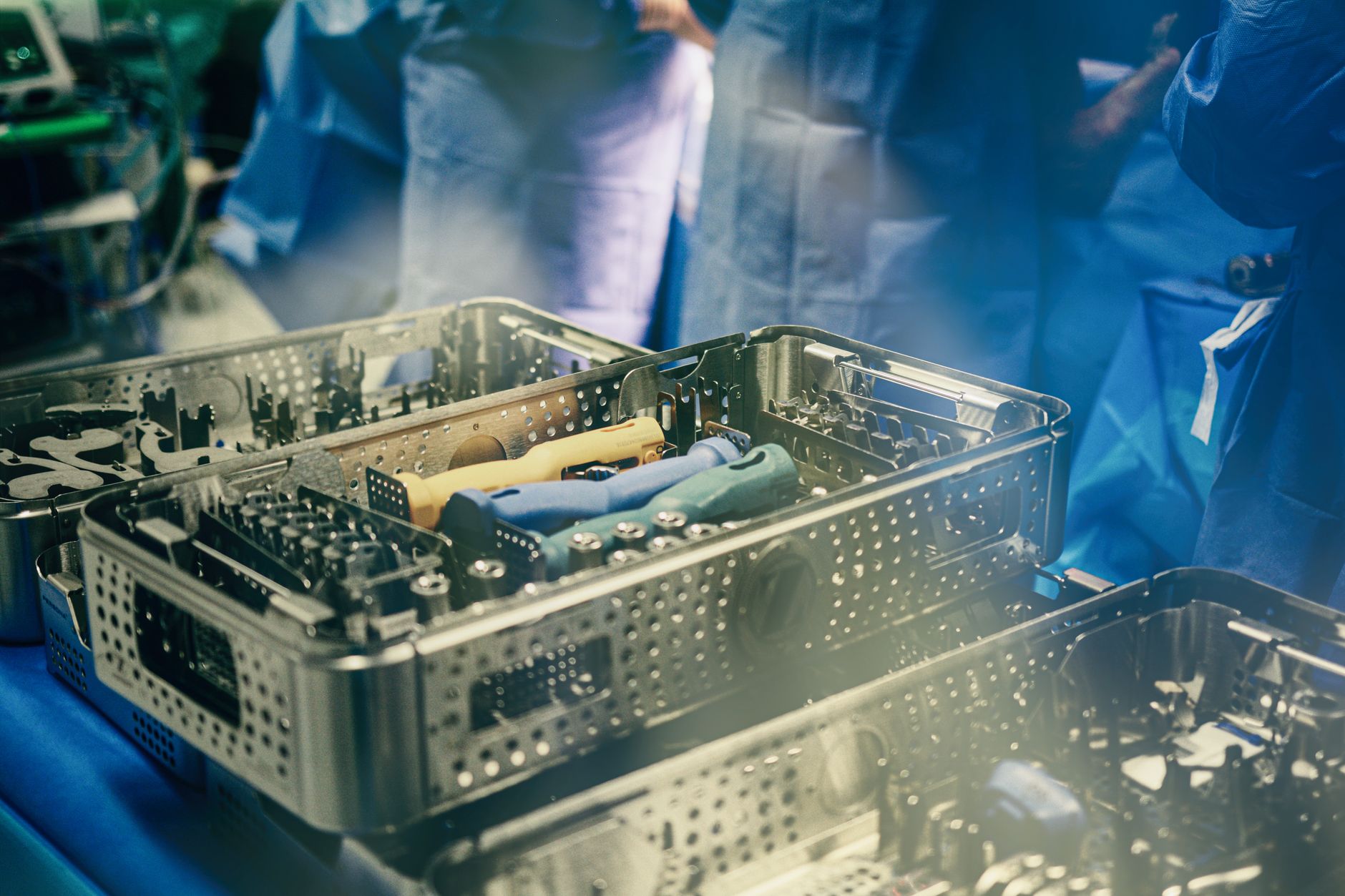 surgical tools organized in metal trays on a blue background